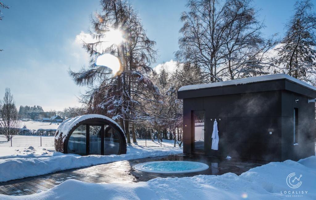 Saunas extérieurs sous la neige au centre wellness du Domaine des Hautes Fagnes à Ovifat