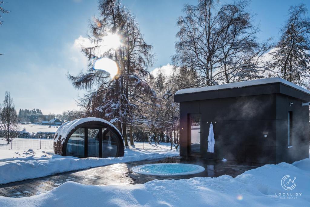 Saunas extérieurs sous la neige au centre wellness du Domaine des Hautes Fagnes à Ovifat