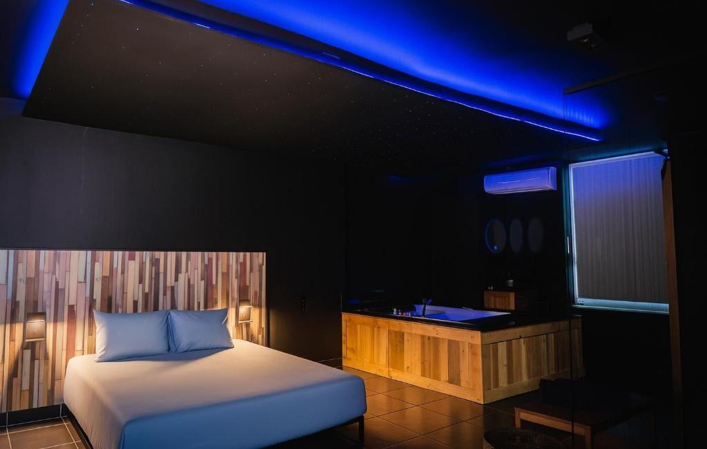 Jacuzzi moderne avec éclairage d'ambiance bleu situé dans la chambre du Loft Ardent à Liège.