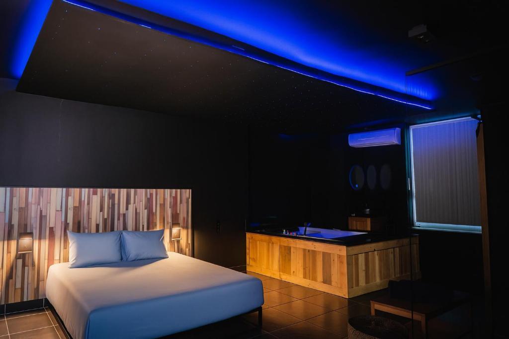 Jacuzzi moderne avec éclairage d'ambiance bleu situé dans la chambre du Loft Ardent à Liège.